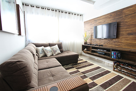 tufted brown sectional couch near modern brown wooden TV unit