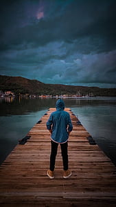 Man Wearing Blue Hoodie Standing On Wooden Dock