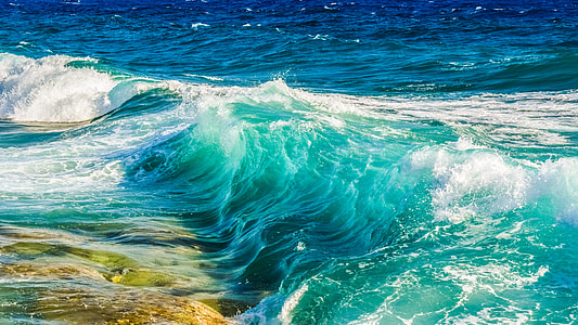 waves rush to shore during daytime