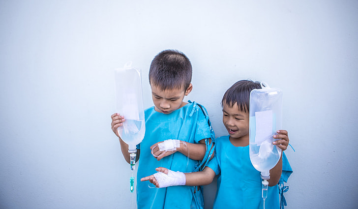 two patient boys holding dextrose bags