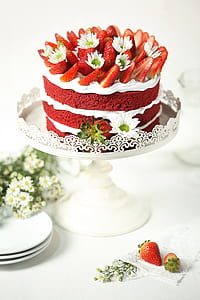 round icing covered cake with sliced strawberry on top