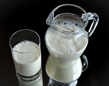milk in clear glass pitcher and cup