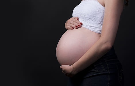 closeup photo of a pregnant woman holding her tummy