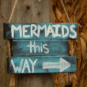photo of mermaids this way signage