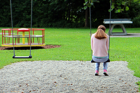 woman sitting on swing in the playground wallpaper