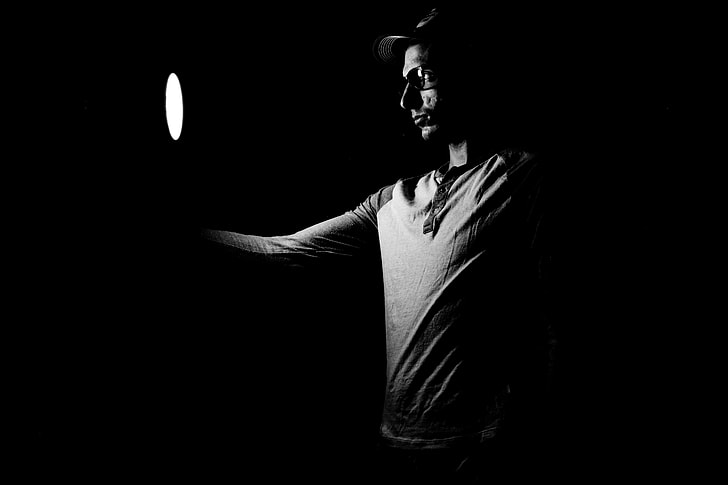 man holding round light inside dark room
