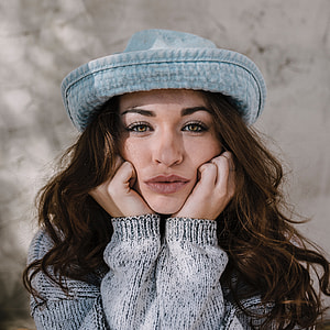 woman wearing blue hat and gray sweater