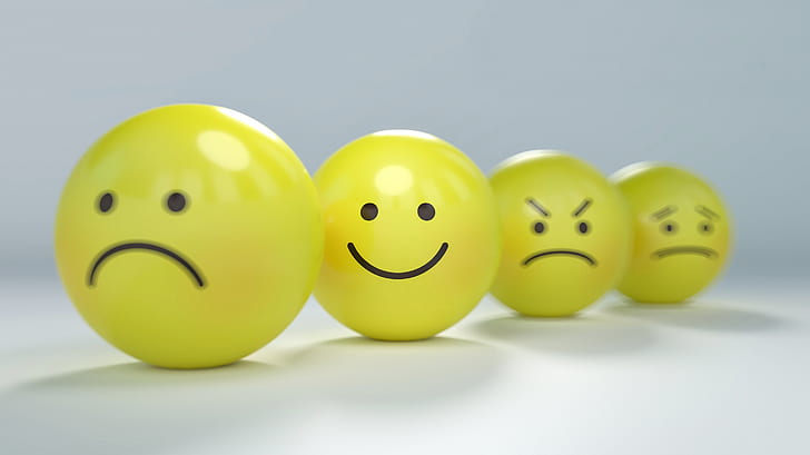 four assorted emoji balls focusing on smiley emoji