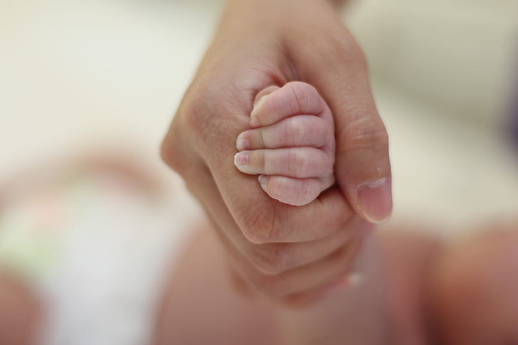 person holding baby's hand