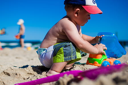 boy playing toy on white sand