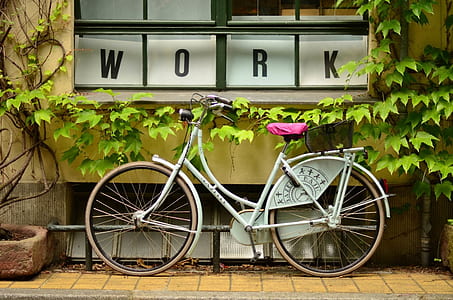 female beach cruiser parked beside wall with work signage
