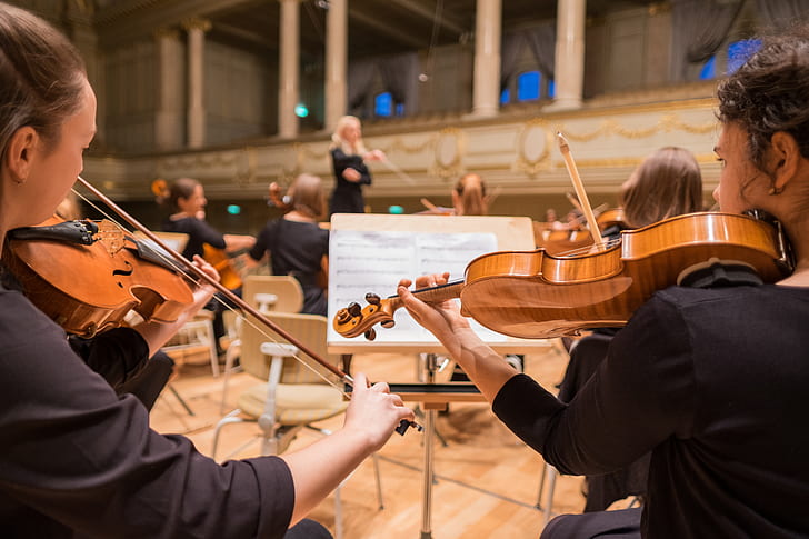 photograph of group of people playing violins