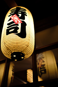 turned on beige and black kanji script-printed oil paper lantern