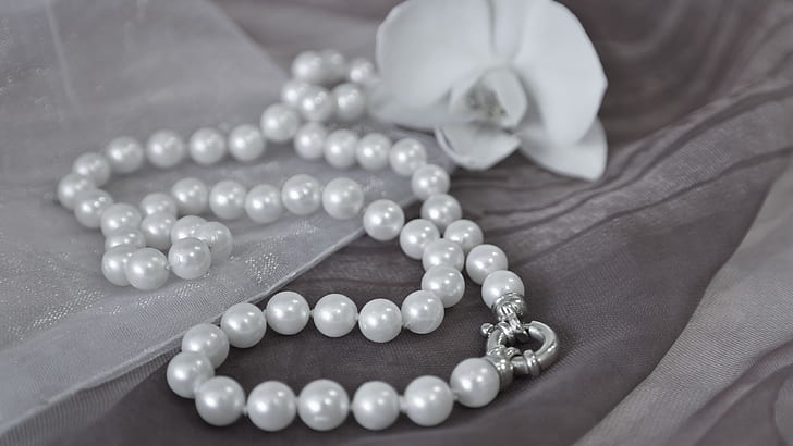 beaded white pearl necklace beside flower