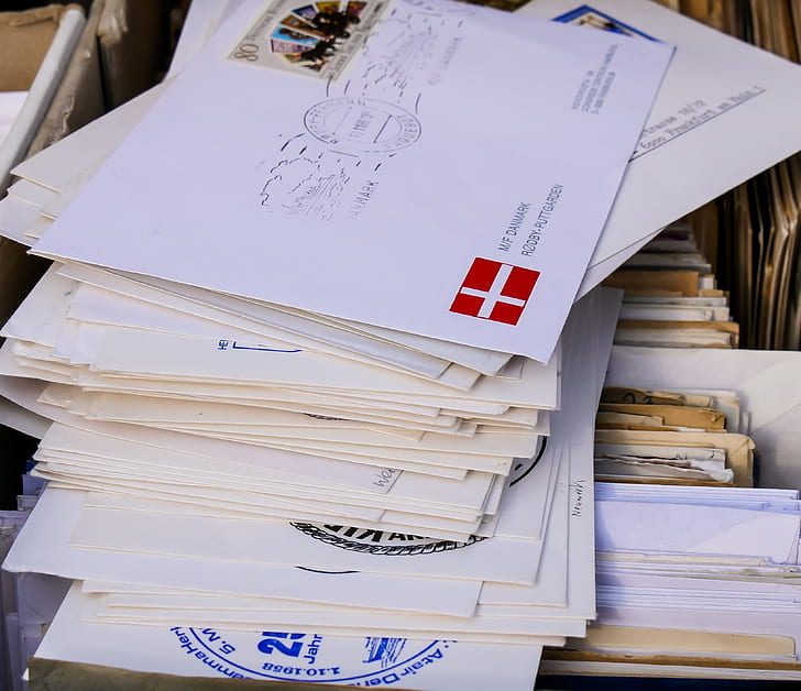 pile of envelops on top of folders
