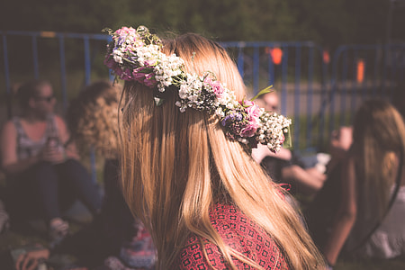 blonde haired in red top wearing flower crown in tilt shift photography