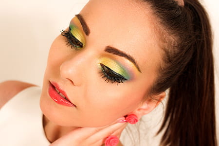 photo of woman wearing white top with green eyeshadow and red lips