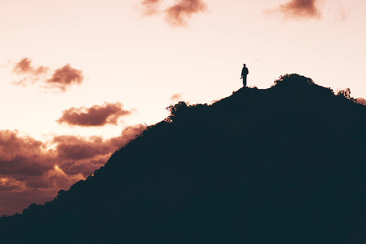 silhouette photography of person on top of mountain