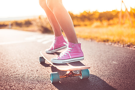 Young Girl with Pink Shoes Riding a Longboard