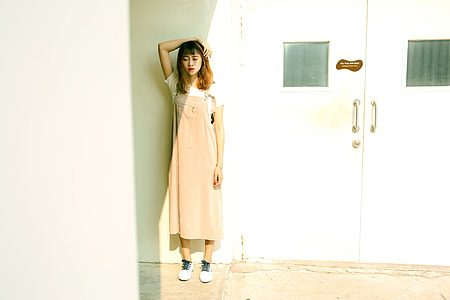 girl standing beside closed door during daytime