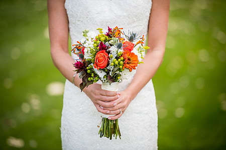 woman in white dress holding bouquet of flowers