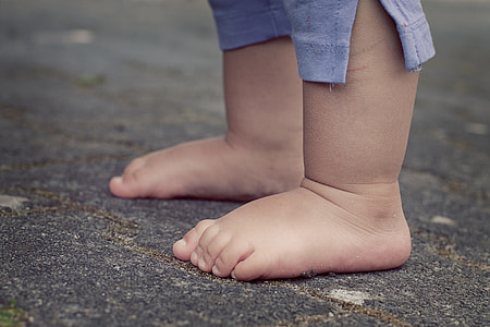 toddler standing with bare foot standing