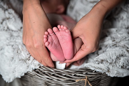 person holds baby's feet
