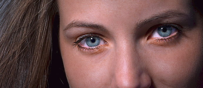 closed up photo of female with blue eyes
