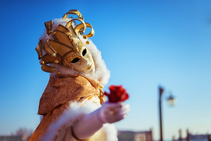 selective focus photography of person wearing white and gold mask