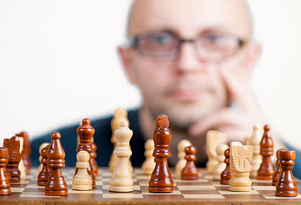 shallow focus of chess board behind of man
