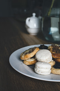 assorted cookies in white ceramic plate on brown wooden tabletop