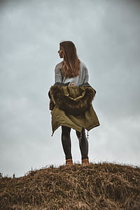 woman wearing beige parka hoodie standing on mountain