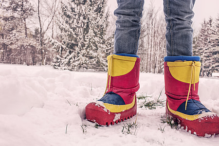 person wearing red-and-yellow snowboots
