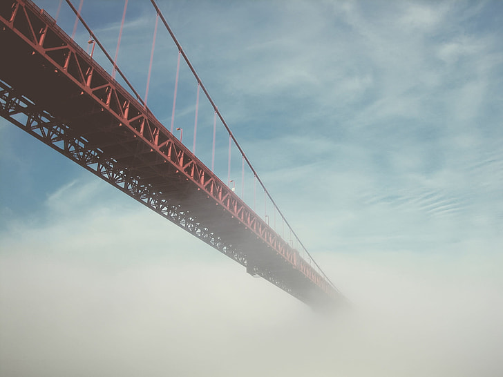 red steel bridge with white clouds photography