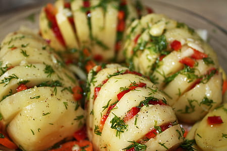 cut cooked potato dish with topped minced red bellpepper