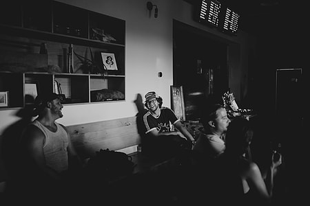 grayscale photo of people sitting inside room