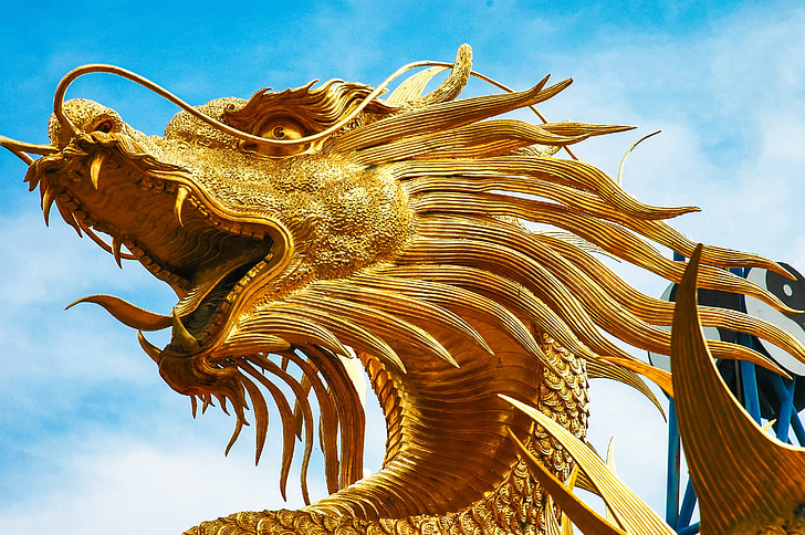 gold Chinese dragon monument during daytime