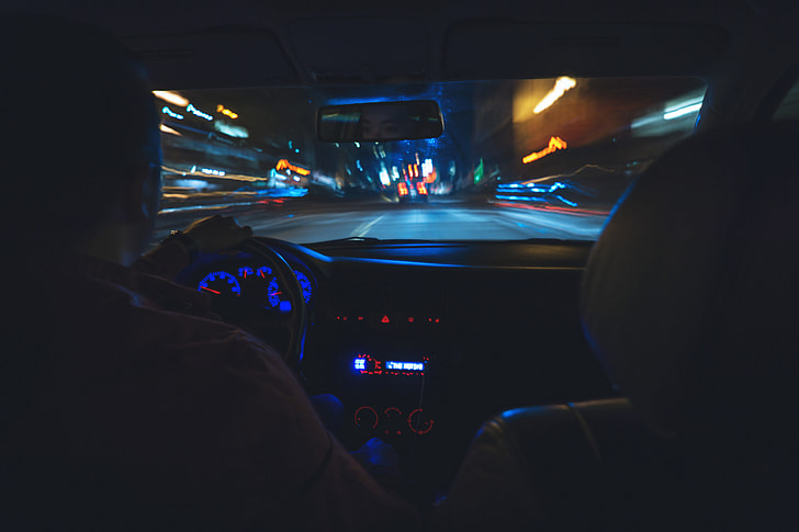 Man driving a car on the road at night