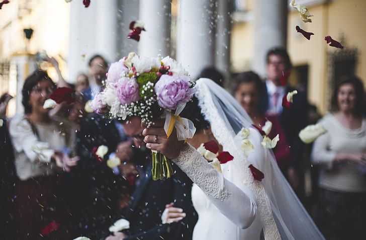 woman wearing wedding dress holding bouquet flower