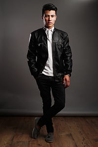 man in black leather jacket, white shirt, and black pants