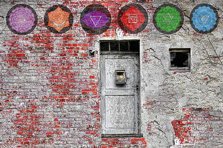 gray metal door and gray and red wall bricks at daytime
