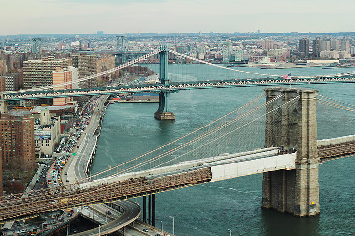 photo of gray concrete suspension bridges above body of water