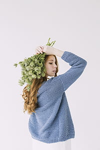 Woman in Blue Knit Cable Sweater Holding Green Petaled Flowers