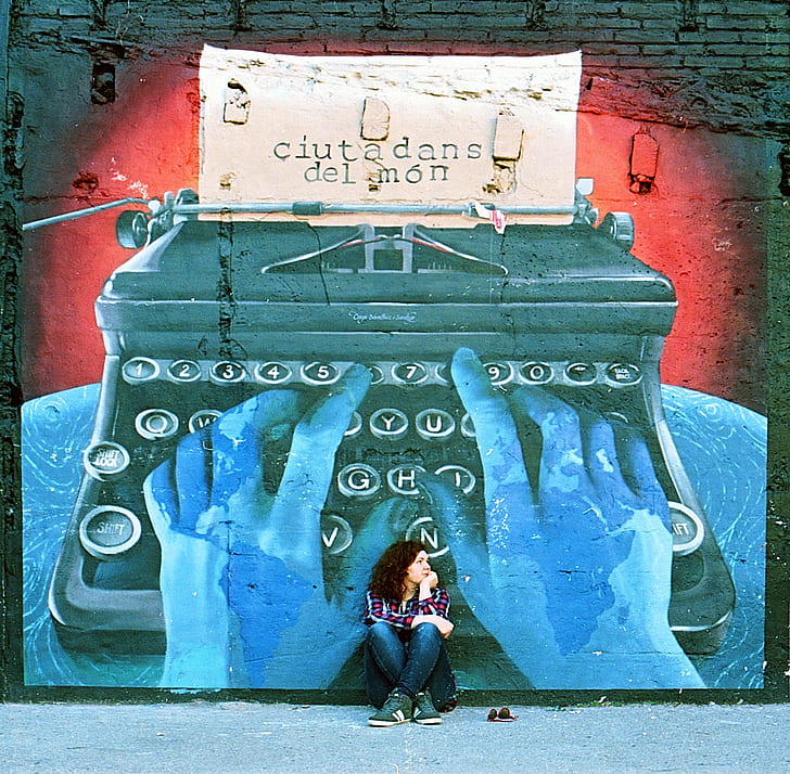 woman sitting on floor beside the typewriter graffiti