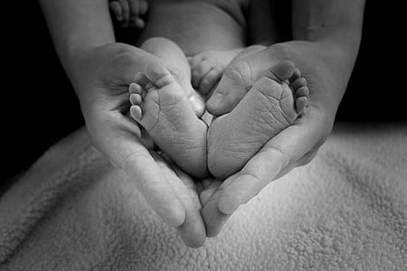 person holding the baby's feet