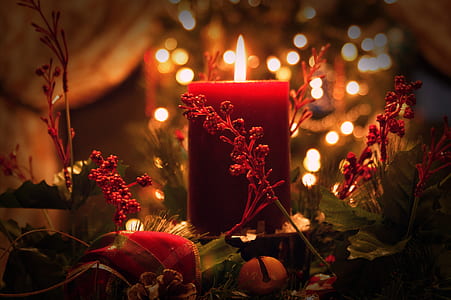 red pillar candle surrounded by artificial plant decor