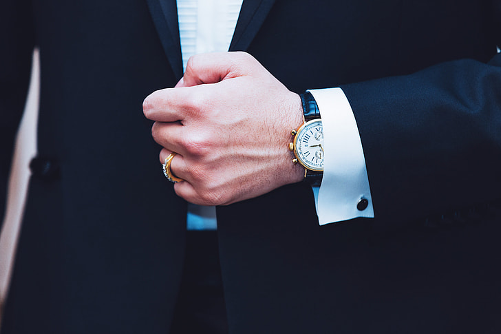 Business man wearing a suit showing hand and watch