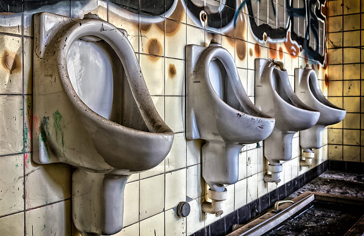 four gray ceramic urinals