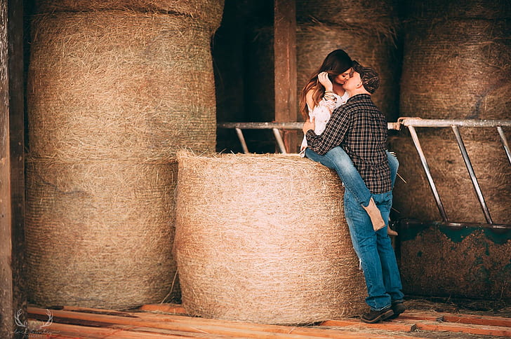 man and woman kissing on hay