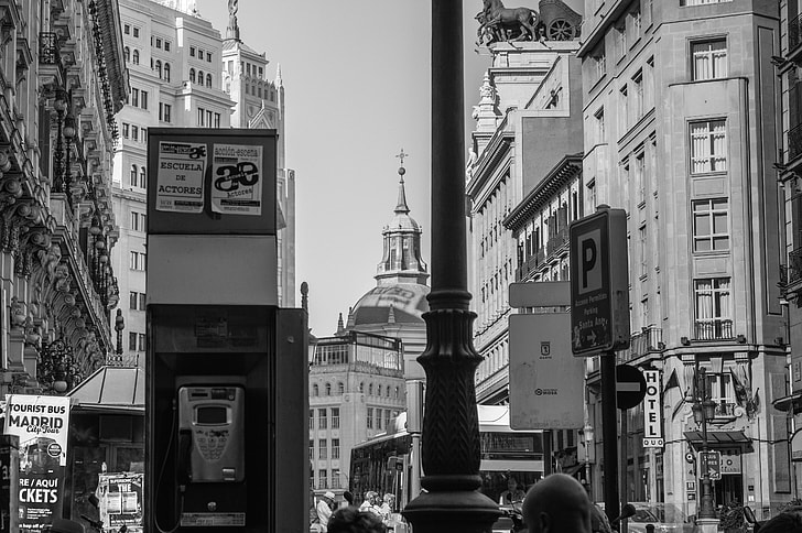gray scale photo of telephone booth and high rise buildings